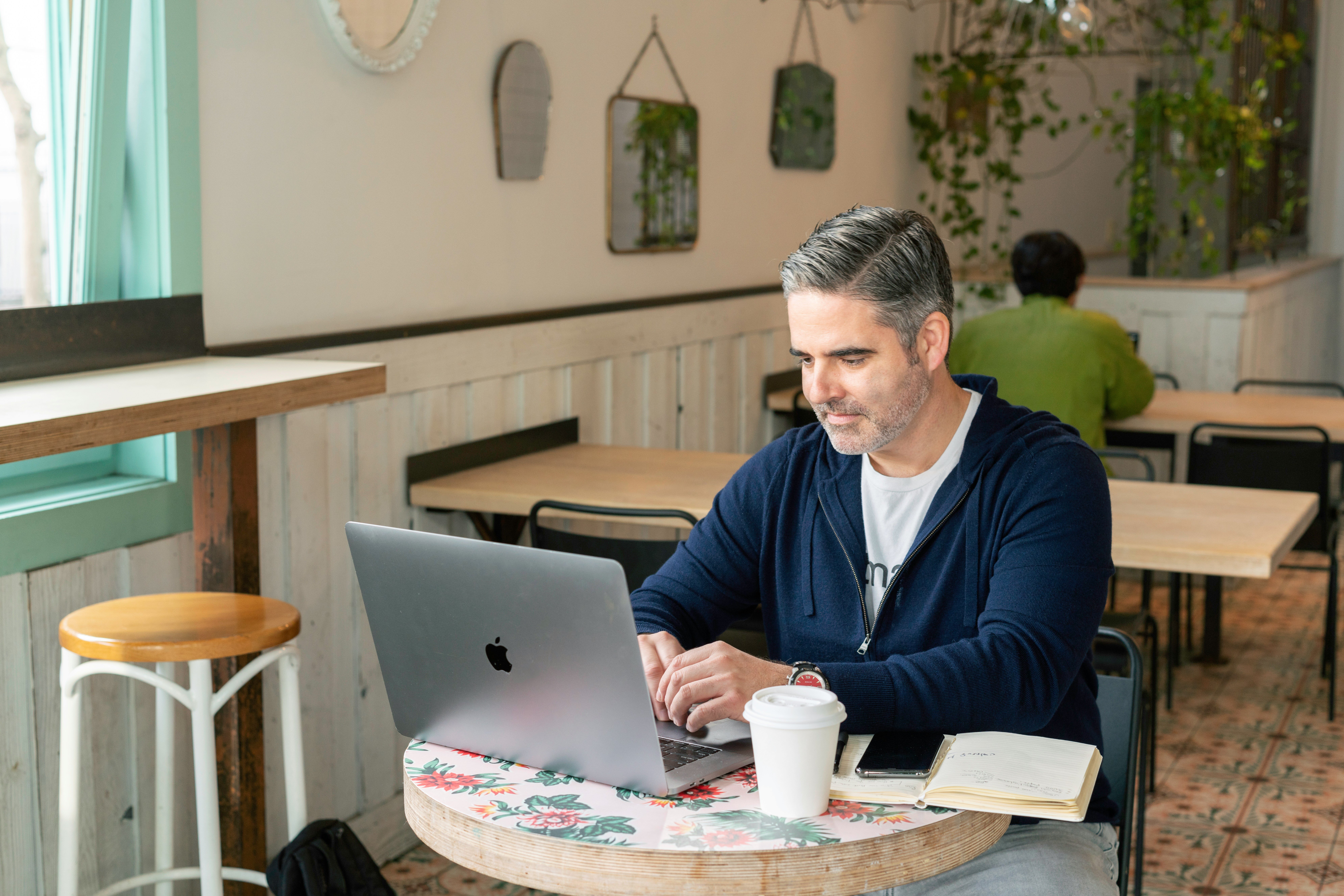 Ein Mann arbeitet in einem Café an einem Laptop
